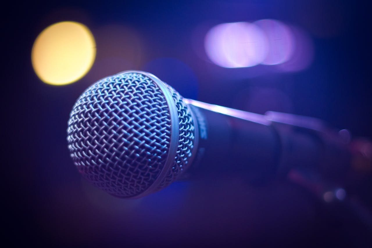 why-choose-us An artistic close-up of a microphone with blurred bokeh lighting, perfect for music themes.